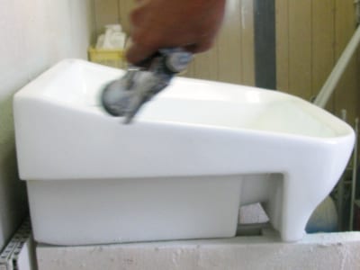 洗面ボウルのヒビ割れ補修の写真、トップコート（上塗り）を行っているところの写真2
